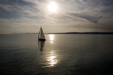 Sailing into the sunset. clipart