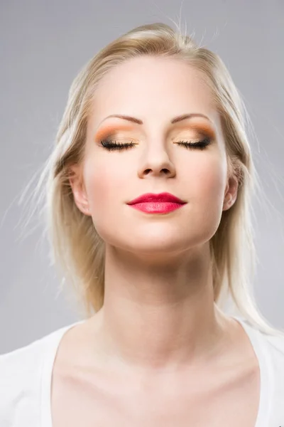 Mujer rubia joven mostrando maquillaje elegante . —  Fotos de Stock