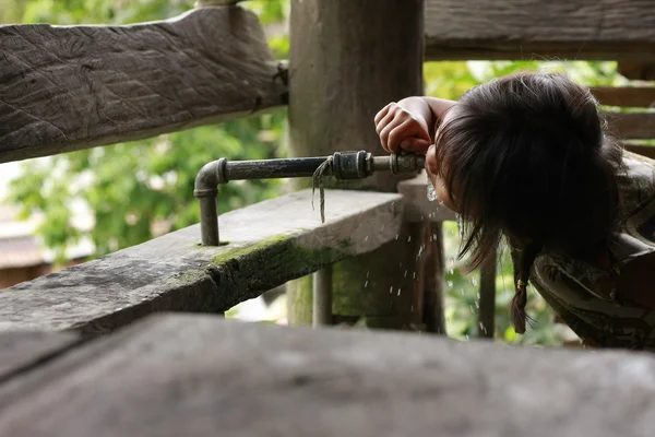 Mangyan stam meisje drinking water uit de kraan — Stockfoto