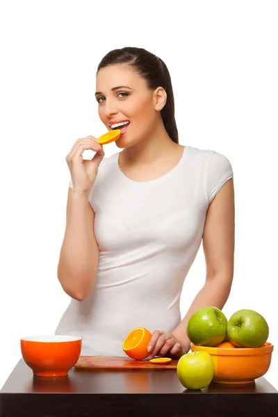 Jovem com frutas que comem segmentos de uma laranja — Fotografia de Stock