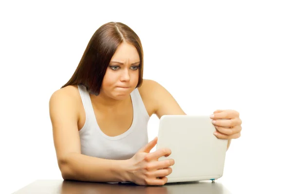 A mulher jovem com o computador portátil atrás de uma mesa — Fotografia de Stock