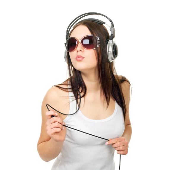 Beautiful girl listens to music through earphones — Stock Photo, Image