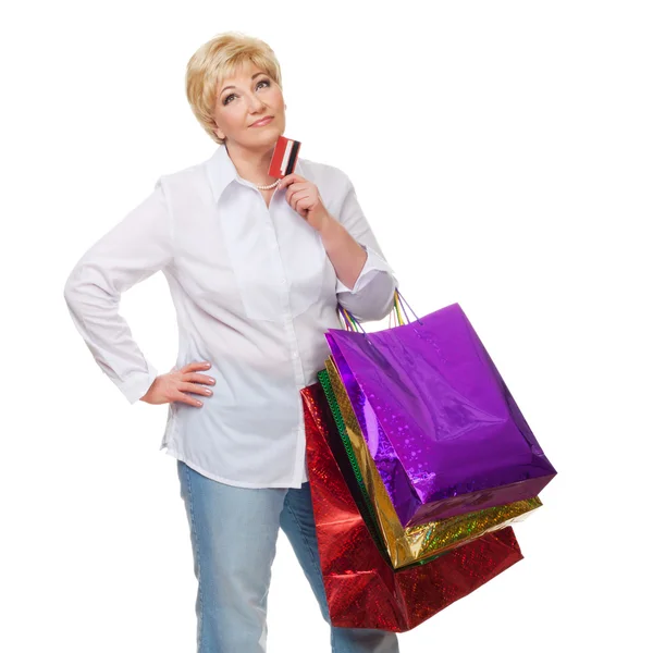 The woman with a credit card and purchases pensively looks upwar Stock Photo
