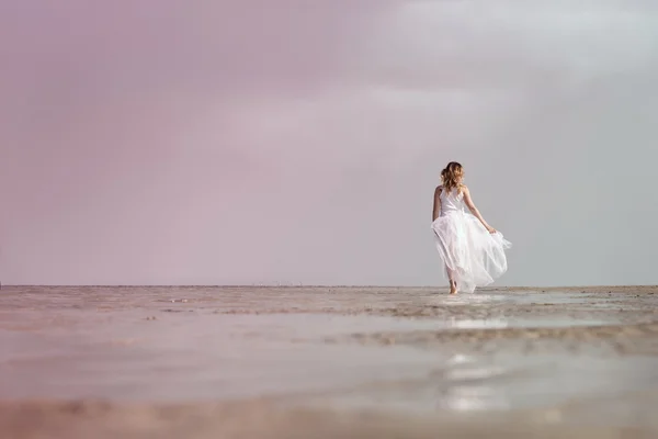Woman walking on the sea shore — Stock Photo, Image