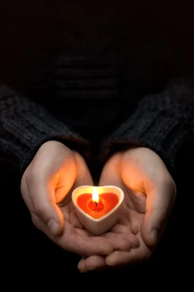 Человеческие руки со свечным сердцем — стоковое фото