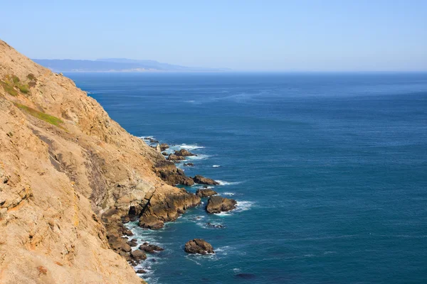 Blauwe oceaan en steile klip — Stockfoto