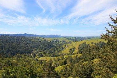 Green hills and cloudy blue sky clipart