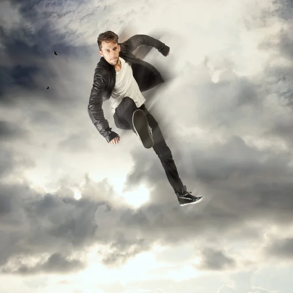 Крутой молодой человек прыгает и пинается — стоковое фото