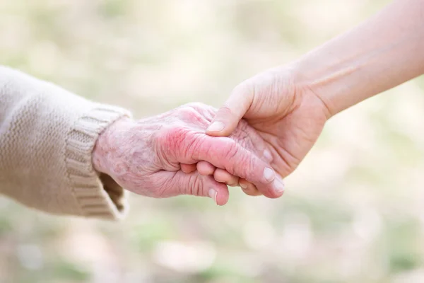 Senior en jonge vrouwen hand in hand — Stockfoto