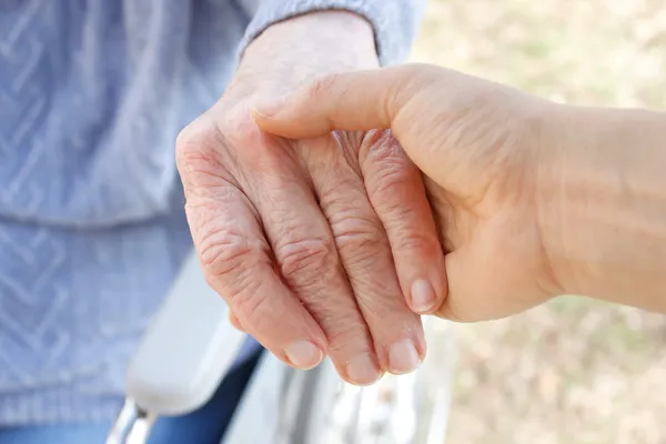 Trzymając rękę seniorów — Zdjęcie stockowe