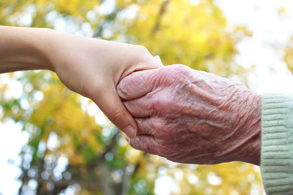 Seniores e jovens de mãos dadas — Fotografia de Stock