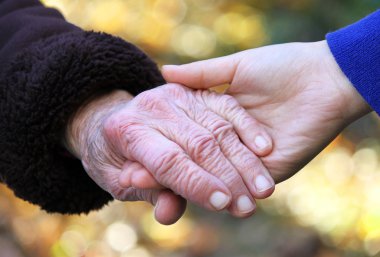 Senior and young holding hands clipart