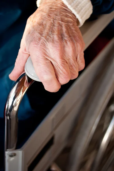 Senior kvinnans hand på en rullstol — Stockfoto