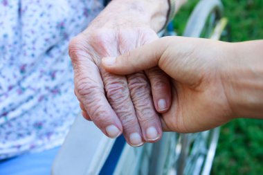 Caregiver holding seniors hand clipart