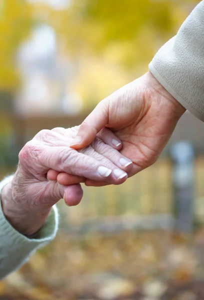 Старшие и молодые держатся за руки — стоковое фото