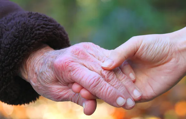 Ręka gospodarstwa seniorów — Zdjęcie stockowe