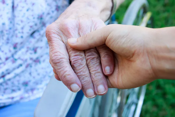 Cuidador segurando a mão dos idosos — Fotografia de Stock