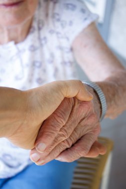 Caregiver holding seniors hand clipart