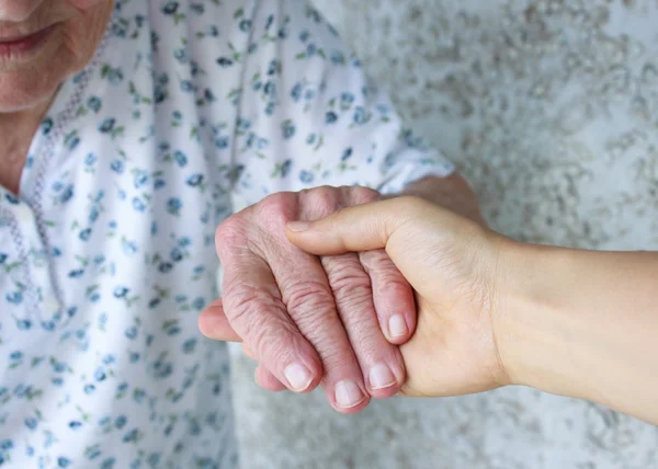 Aide-soignant tenant la main des aînés — Photo
