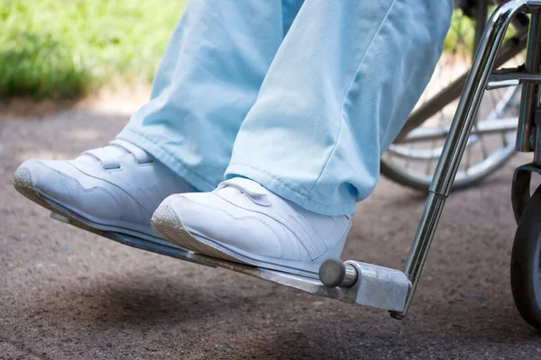 Nohy a nohy ženy sedí na invalidním vozíku — Stock fotografie