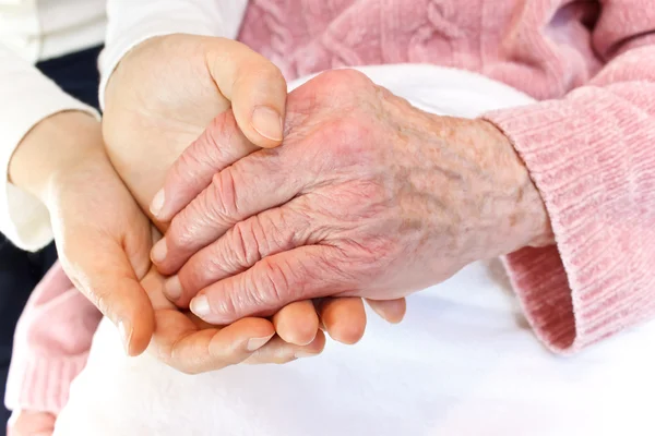 Young holding senior 's hand — стоковое фото