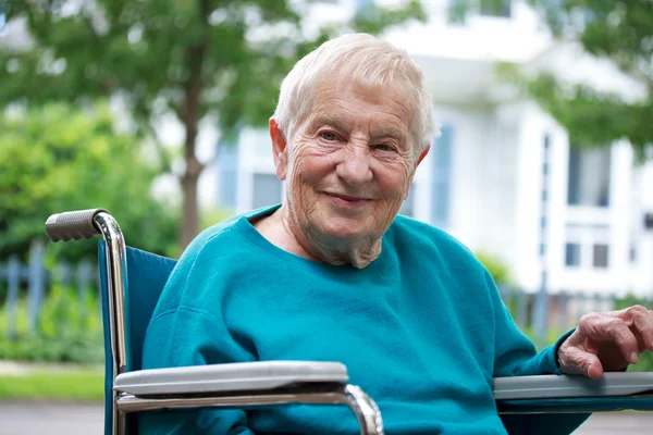 Senhora sênior feliz em cadeira de rodas — Fotografia de Stock