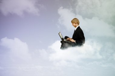 Using a laptop in the clouds clipart