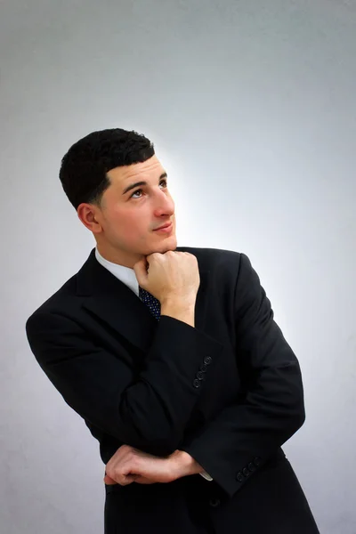 Jovem homem de negócios pensando em terno preto — Fotografia de Stock