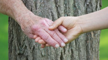 Senior and young woman holding hands clipart