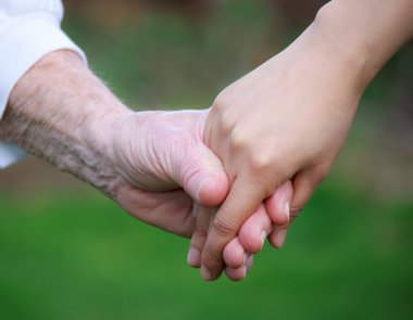 Young holding senior's hand clipart