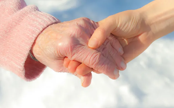 Starsze i młode ręce za ręce — Zdjęcie stockowe