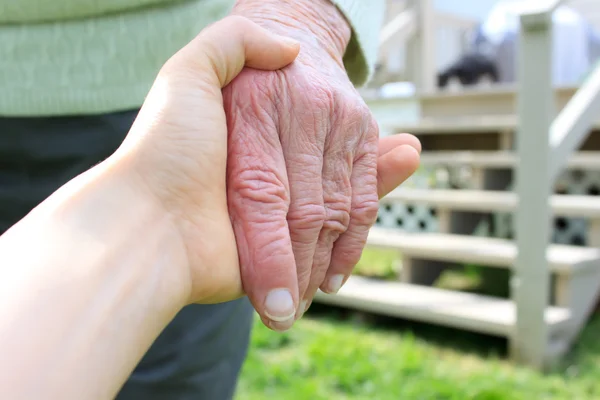 Młody przytrzymanie ręka starszych pani — Zdjęcie stockowe