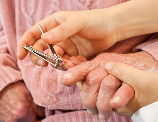 Helpen senior snijden nagel — Stockfoto
