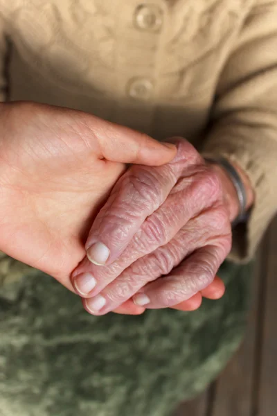 Unga och äldre håller hand — Stockfoto