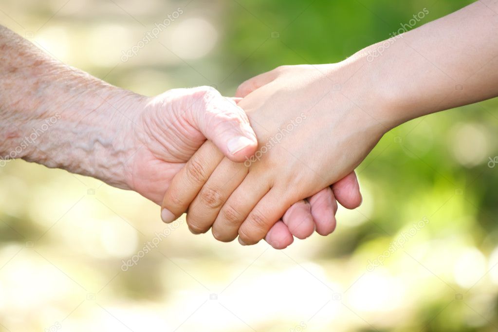 Senior and young women holding hand