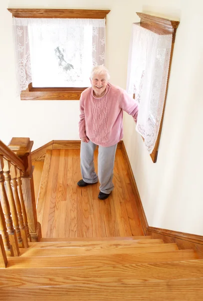Старшая женщина перед лестницей — стоковое фото