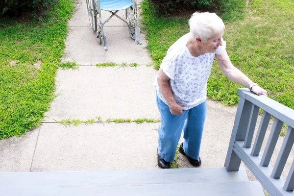 Senior senhora em pé na frente da escada — Fotografia de Stock