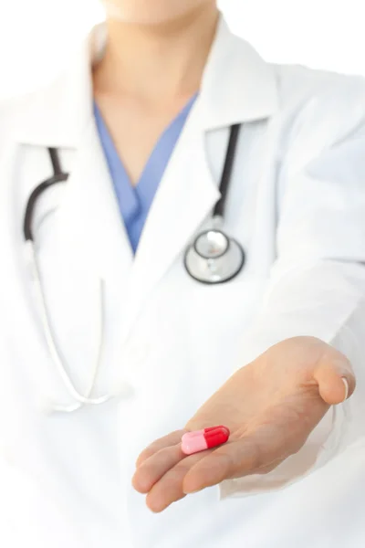 Doutor com jaleco mostrando pílulas — Fotografia de Stock