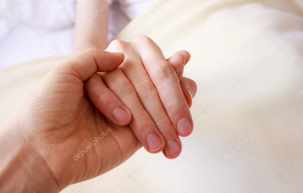 Holding the hand of an ill loved one