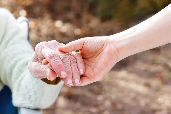 Senior Lady segurando as mãos com o jovem zelador — Fotografia de Stock