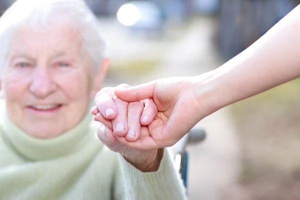 Senior senhora e jovem mulher segurando as mãos — Fotografia de Stock
