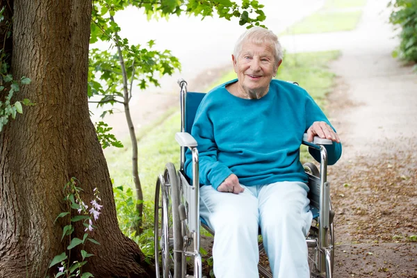 Äldre dam i rullstol leende — Stockfoto