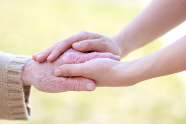 Senior and Young Women Holding Hands clipart