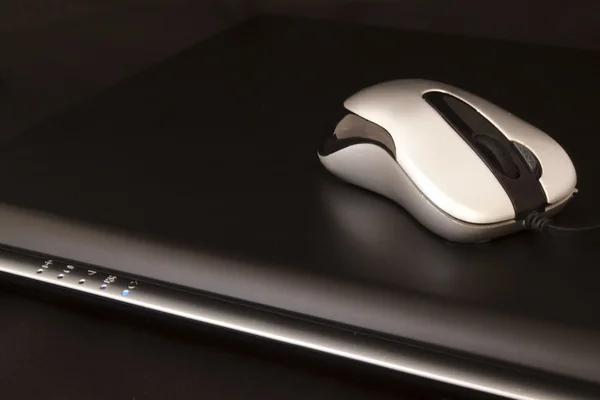 Ноутбук и маленькая серебряная мышь — стоковое фото