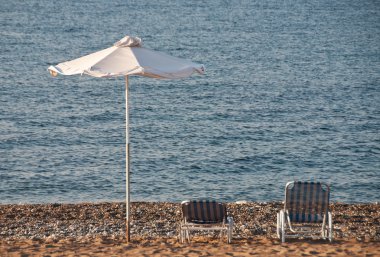 parasol en ligstoelen op het strand