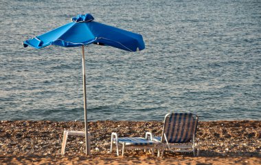 parasol en ligstoelen op het strand