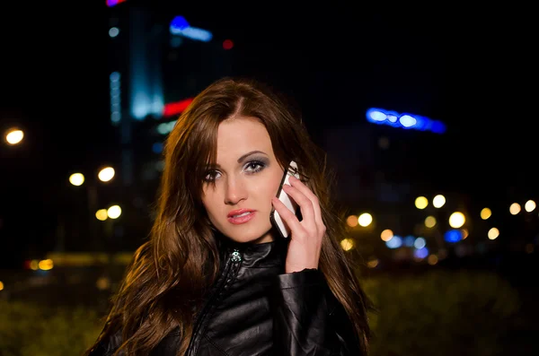 Красивая деловая женщина разговаривает по мобильному телефону ночью в центре города — стоковое фото