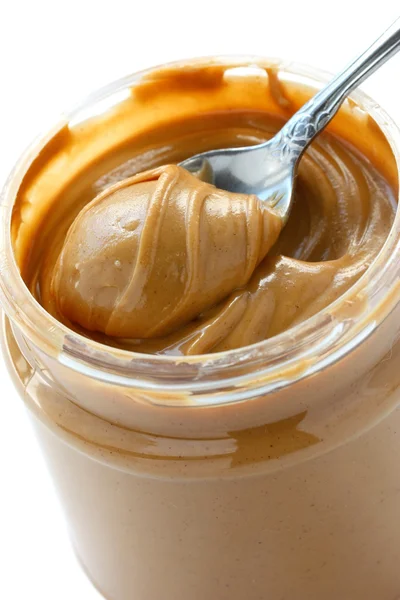 Um frasco aberto de manteiga de amendoim com colher — Fotografia de Stock