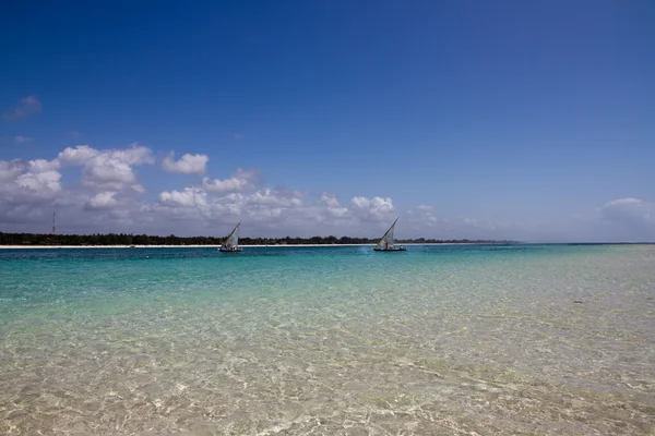 Veleros en el océano cerca de la playa de arena blanca con cielo azul — Foto de Stock