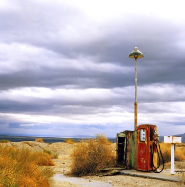 Old gas pump at border of the desert clipart